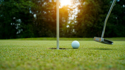 Golf balls that are going to be hole by golfers at the green grass golf course at sunset.