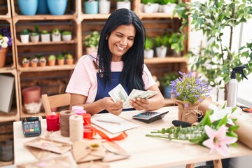 Wall Mural - Middle age hispanic woman florist smiling confident counting dollars at florist