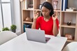 © Krakenimages.com - Young african american woman using laptop doing yoga exercise at home