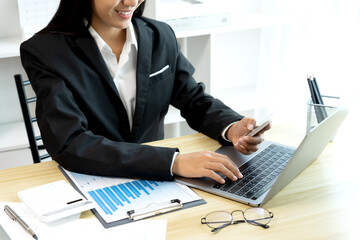 Sticker - businesswoman Sitting at desk using smartphone and laptop with data from graph