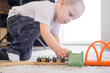 © Zireael - A little boy rides trains on the railroad at home on the floor. The kid spends time playing.