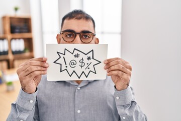 Canvas Print - Middle east man with beard holding banner with swear words afraid and shocked with surprise and amazed expression, fear and excited face.