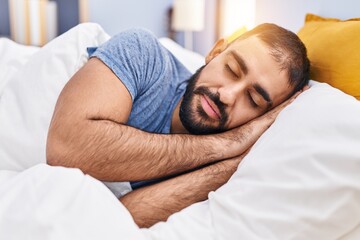 Young hispanic man lying on bed sleeping at bedroom