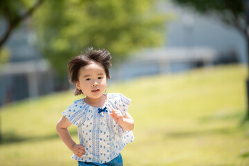 Poster - 新緑の公園で遊ぶ3歳の女の子