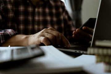 Poster - businessman used smartphone laptop and calculator on the table