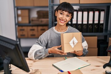 Canvas Print - Young hispanic woman working at small business ecommerce looking positive and happy standing and smiling with a confident smile showing teeth