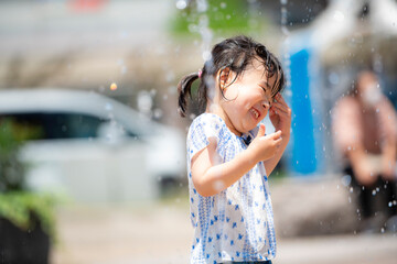 Poster - 広場の噴水で水遊びしている3歳の女の子