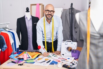 Canvas Print - Young bald man tailor smiling confident drawing clothing design at tailor shop