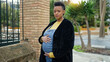 © Krakenimages.com - Young pregnant woman touching belly with relaxed expression at street