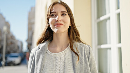 Poster - Young hispanic woman standing with serious expression looking to the side at street