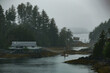 Grey, misty, foggy morning in archipelago near Sitka, Alaska with small islands channel cruising and houses