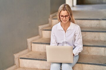 Poster - Young blonde woman smiling confident using laptop at street