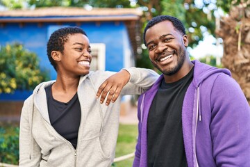 Canvas Print - Man and woman couple wearing sportswear standing together at park