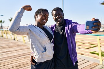 Canvas Print - Man and woman couple wearing sportswear make selfie by the smartphone at street