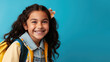 Portrait of smiling schoolgirl with school bag isolated on blue background. Back to school concept. AI Generated.