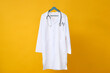 © Atlas - A doctor's white coat with a stethoscope on a yellow background