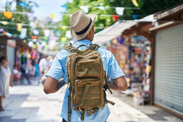 Poster - African american man tourist walking on back view at street market