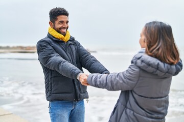 Canvas Print - Man and woman couple smiling confident dancing at seaside