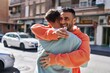 Two man couple hugging each other surprise with engagement ring at street