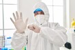 © Krakenimages.com - Young latin man scientist wearing covid protection uniform and gloves at laboratory