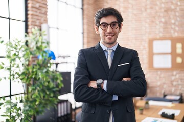 Canvas Print - Young hispanic man business worker standing with arms crossed gesture at office