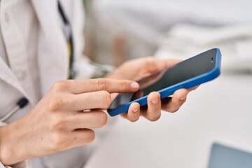 Poster - Young caucasian woman doctor using smartphone working at clinic