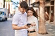 © Krakenimages.com - Mand and woman couple hugging each other using smartphone at street