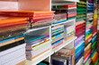 © Taras Grebinets - Close-up shelves with assortment of copybooks, sketchbooks, cardboard sheets and color paper in a school stationery shop