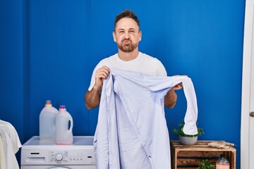 Sticker - Middle age caucasian man holding shirt with sweat puffing cheeks with funny face. mouth inflated with air, catching air.