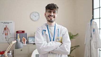 Poster - Young hispanic man doctor smiling confident standing with crossed arms at clinic