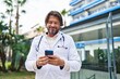 © Krakenimages.com - Middle age man doctor smiling confident using smartphone at hospital