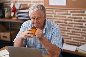 Canvas Print - Middle age grey-haired man business worker using laptop drinking coffee at office