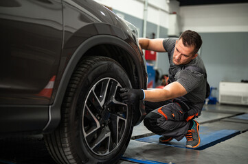 the mechanic checks the tires in the service station