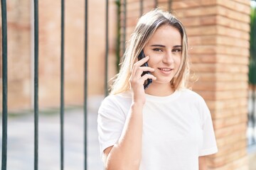 Poster - Young blonde woman smiling confident talking on the smartphone at street