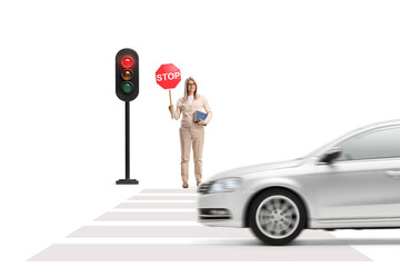 Canvas Print - Young woman holding a book and a stop sign and standing near traffic lights