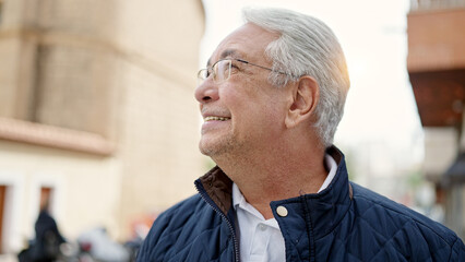 Wall Mural - Middle age man with grey hair smiling confident looking up at street