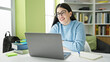 © Krakenimages.com - Young hispanic woman student using laptop smiling at library university