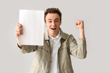 Poster - Happy male student with answer sheet for school test on grey background