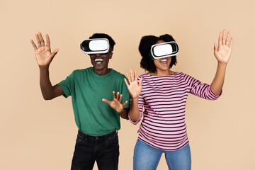 Smiling surprised millennial african american guy and woman with big belly in VR glasses enjoy play game