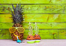 Creative Card Postcard Happy Birthday With Number  39. Background Character Pineapple In Festive Glasses. Copy Space Anniversary Card On Yellow Colorful Wooden Background.