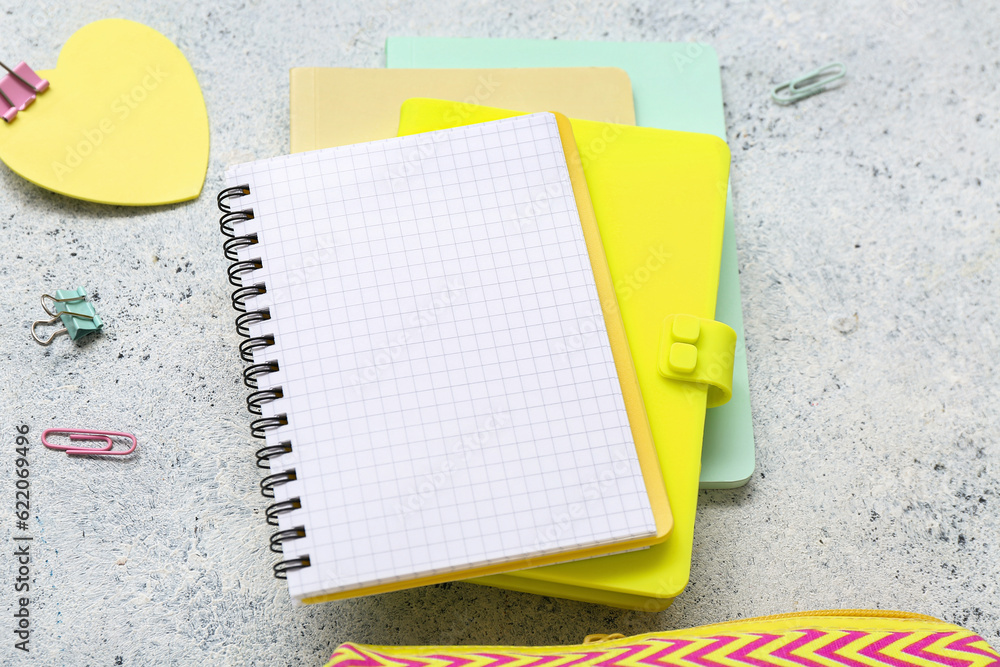 Blank notebook with different stationery on grunge grey background