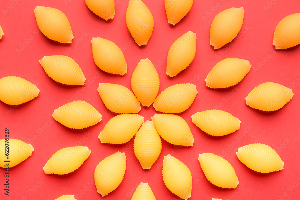 Uncooked pasta on red background
