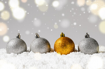 Canvas Print - silver and golden decorative christmas balls on snow against grey festive background