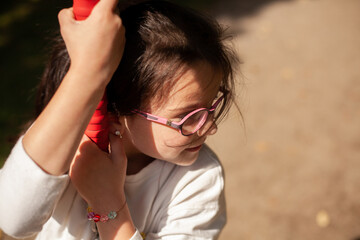 Wall Mural - Portrait of a cute little girl swinging on a swing in the park