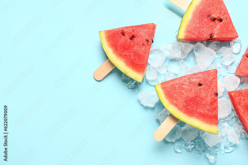 Sweet watermelon sticks and ice cubes on blue background