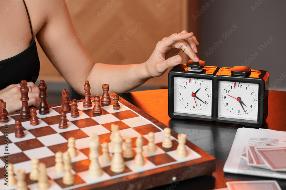 Young woman playing chess at table, closeup