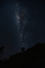 Wall Mural - The Milky Way Galaxy moving over the mountain ridge. Night lapse from night to day. Starry night.