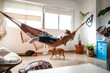 © ADDICTIVE STOCK - Dreamy woman lying on hammock with cute cats on floor