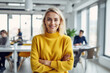 © ADDICTIVE STOCK - Generative AI image of portrait of smiling young female employee in sweater looking at camera while standing with hands crossed in blurred and illuminated office with colleagues