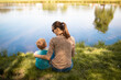 © kieferpix - Bonding family mother and child by tranquil lake, surrounded by nature's beauty